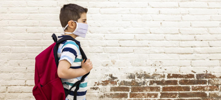 Child wearing mask and backpack
