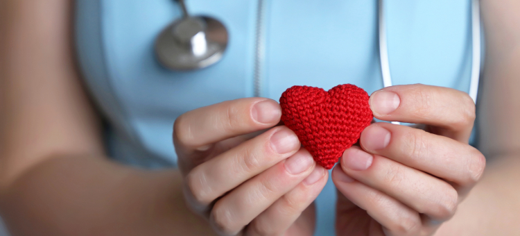 Health care provider holding crocheted heart.